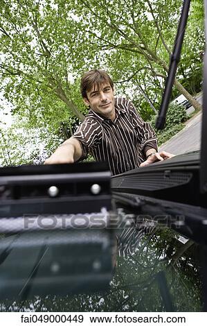 Stock Photo - Man washing car windshield with squeegee. Fotosearch