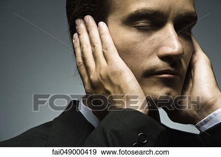 Man with hands held over ears and eyes closed View Large Photo Image Stock Photo - Man with hands held over ears and eyes closed. Fotosearch