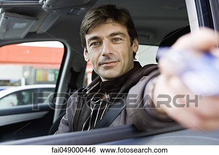 Mid-adult man in drive-thru handing credit card to check-out window clerk View Large Photo Image Stock Photograph - Mid-adult man in drive-thru handing credit card to check-out window clerk. Fotosearch