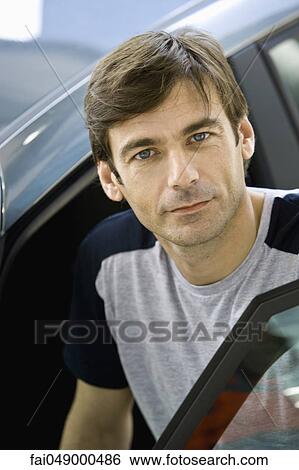 Mid-adult man preparing to get into car View Large Photo Image Stock Photograph - Mid-adult man preparing to get into car. Fotosearch