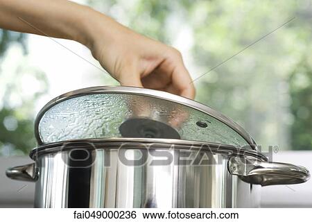 Person removing lid from cooking pot View Large Photo Image Stock Photograph - Person removing lid from cooking pot. Fotosearch