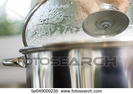Person removing lid from steaming pot View Large Photo Image Stock Photography - Person removing lid from steaming pot. Fotosearch