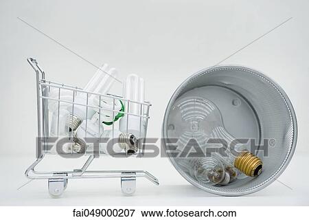 Shopping cart containing energy efficient light bulbs next to garbage can containing conventional light bulbs View Large Photo Image Stock Photo - Shopping cart containing energy efficient light bulbs next to garbage can containing conventional light bulbs. Fotosearch