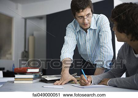Teacher explaining assignment to student View Large Photo Image Stock Image - Teacher explaining assignment to student. Fotosearch