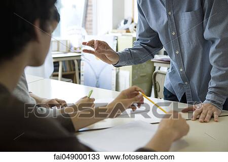 Stock Image - Teacher lecturing students, cropped. Fotosearch