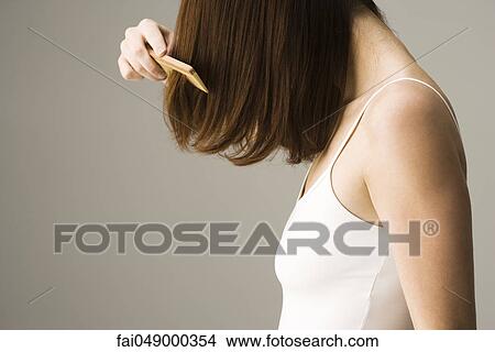 Picture - Woman combing hair. Fotosearch