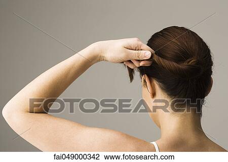 Woman styling hair, rear view View Large Photo Image Stock Image - Woman styling hair, rear view. Fotosearch