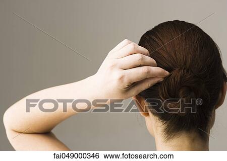 Woman styling hair, rear view View Large Photo Image Stock Photograph - Woman styling hair, rear view. Fotosearch