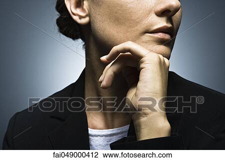 Woman with hand held under chin contemplatively looking away View Large Photo Image Stock Image - Woman with hand held under chin contemplatively looking away. Fotosearch