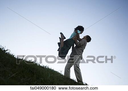 Young couple, woman jumping into man's arms View Large Photo Image Stock Image - Young couple, woman jumping into man's arms. Fotosearch