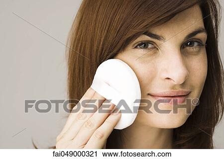 Young woman applying facial powder View Large Photo Image Stock Image - Young woman applying facial powder. Fotosearch