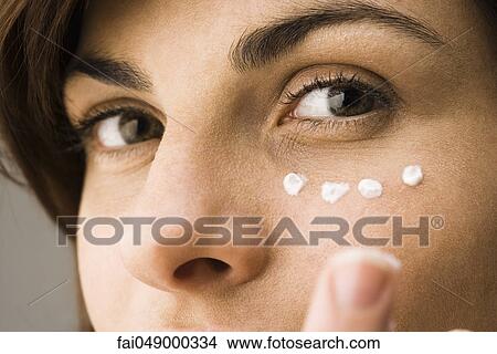 Young woman applying undereye cream View Large Photo Image Picture - Young woman applying undereye cream. Fotosearch