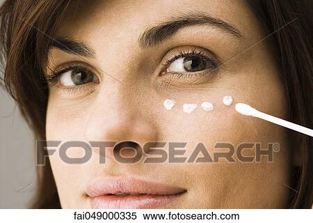 Young woman applying undereye cream View Large Photo Image Stock Photography - Young woman applying undereye cream. Fotosearch