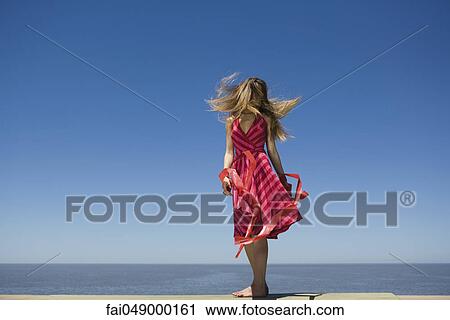 Young woman at beach enjoying sunshine, tossing hair View Large Photo Image Stock Image - Young woman at beach enjoying sunshine, tossing hair. Fotosearch