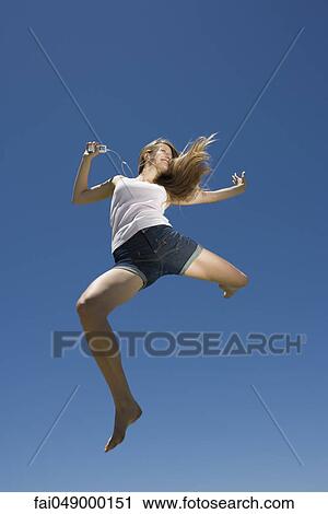 Young woman dancing, jumping outdoors View Large Photo Image Stock Image - Young woman dancing, jumping outdoors. Fotosearch