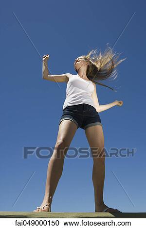 Stock Image - Young woman dancing outdoors. Fotosearch