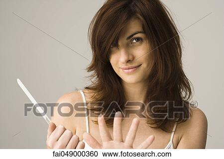 Young woman filing nails View Large Photo Image Stock Image - Young woman filing nails. Fotosearch