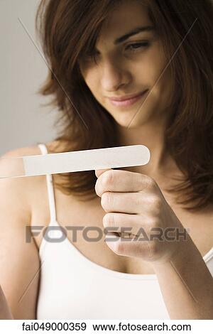 Young woman filing nails View Large Photo Image Stock Photo - Young woman filing nails. Fotosearch