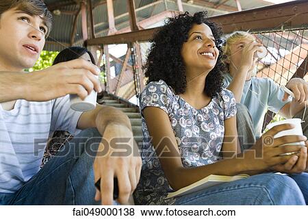Young woman hanging out with friends watching sports event View Large Photo Image Stock Photo - Young woman hanging out with friends watching sports event. Fotosearch