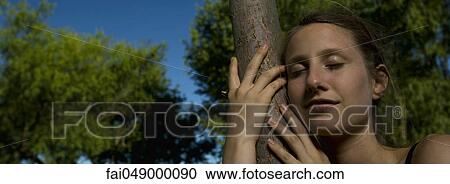 Young woman hugging tree, close-up View Large Photo Image Stock Image - Young woman hugging tree, close-up. Fotosearch