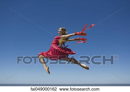 Young woman leaping, midair View Large Photo Image Stock Image - Young woman leaping, midair. Fotosearch