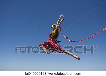 Young woman leaping, midair View Large Photo Image Stock Image - Young woman leaping, midair. Fotosearch