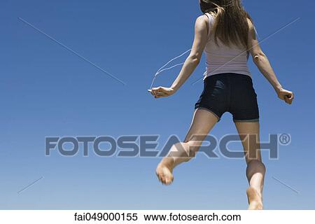 Young woman listening toMP3 player, jumping in midair View Large Photo Image Stock Photography - Young woman listening toMP3 player, jumping in midair. Fotosearch