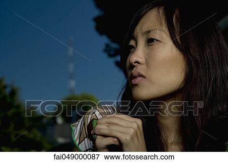 Young woman looking away, hands clasped and brow furrowed, portrait View Large Photo Image Stock Photo - Young woman looking away, hands clasped and brow furrowed, portrait. Fotosearch