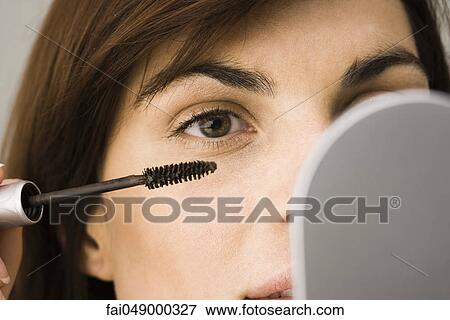 Young woman putting on mascara View Large Photo Image Stock Photo - Young woman putting on mascara. Fotosearch
