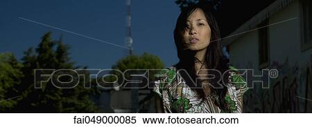 Young woman standing outdoors, portrait View Large Photo Image Stock Photography - Young woman standing outdoors, portrait. Fotosearch