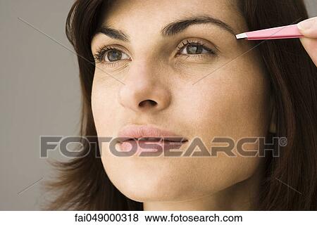 Young woman tweezing eyebrows View Large Photo Image Stock Photo - Young woman tweezing eyebrows. Fotosearch