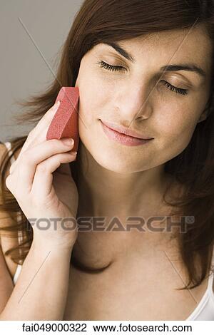 Young woman using cosmetic sponge View Large Photo Image Stock Image - Young woman using cosmetic sponge. Fotosearch