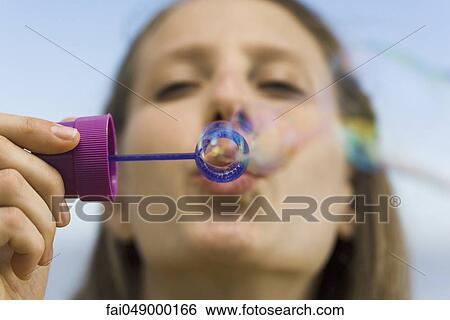 Young woman with bubble wand blowing bubbles View Large Photo Image Stock Photograph - Young woman with bubble wand blowing bubbles. Fotosearch