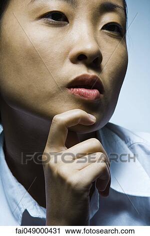 Young woman with hand under chin contemplatively looking away View Large Photo Image Stock Image - Young woman with hand under chin contemplatively looking away. Fotosearch