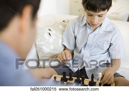 Boy playing chess with his father, cropped View Large Photo Image Stock Photography - Boy playing chess with his father, cropped. Fotosearch