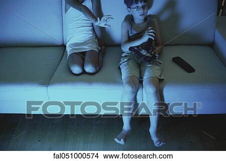 Boy playing video game, sister reaching for joystick View Large Photo Image Picture - Boy playing video game, sister reaching for joystick. Fotosearch