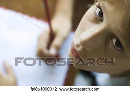 Boy writing in notebook, pausing work to look up at camera View Large Photo Image Stock Image - Boy writing in notebook, pausing work to look up at camera. Fotosearch