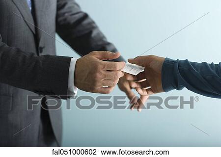 Stock Image - Businessman handing business card to client. Fotosearch