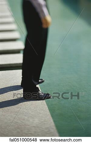 Businessman standing at edge of pool, low section View Large Photo Image Stock Photo - Businessman standing at edge of pool, low section. Fotosearch