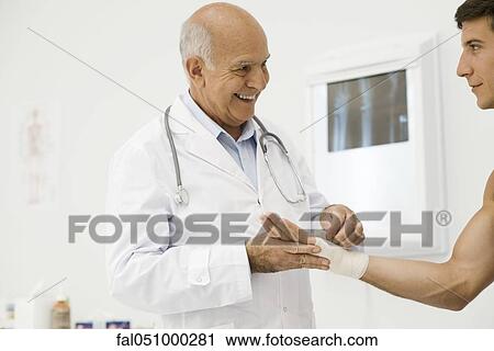 Doctor bandaging patient's wrist View Large Photo Image Stock Image - Doctor bandaging patient's wrist. Fotosearch