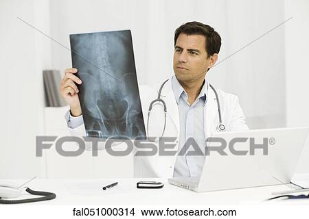 Doctor studying x-ray View Large Photo Image Picture - Doctor studying x-ray. Fotosearch
