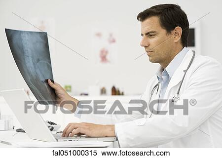 Doctor studying x-ray View Large Photo Image Stock Photography - Doctor studying x-ray. Fotosearch