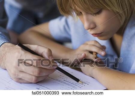 Elementary school student being helped by teacher in class View Large Photo Image Stock Image - Elementary school student being helped by teacher in class. Fotosearch