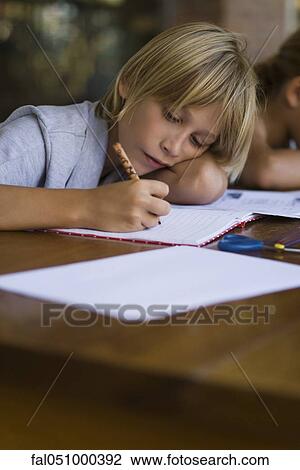 Stock Image - Elementary school student concentrating on school work. Fotosearch