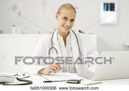 Female doctor at work at desk View Large Photo Image Stock Photograph - Female doctor at work at desk. Fotosearch