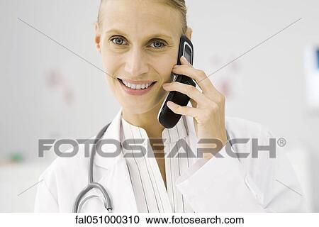 Stock Image - Female doctor on phone call, portrait. Fotosearch