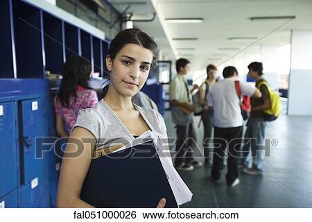 Female high school student standing in hall lined with lockers View Large Photo Image Stock Photograph - Female high school student standing in hall lined with lockers. Fotosearch