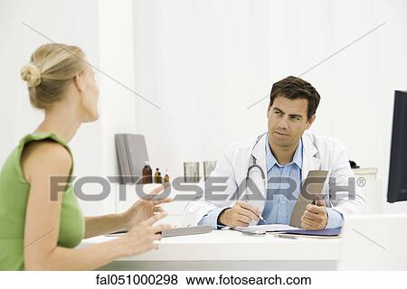 Stock Photo - Female patient speaking with doctor. Fotosearch