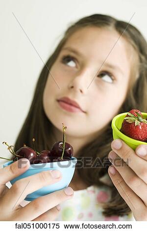 Girl deciding between bowl of cherries and bowl of strawberries View Large Photo Image Stock Photography - Girl deciding between bowl of cherries and bowl of strawberries. Fotosearch