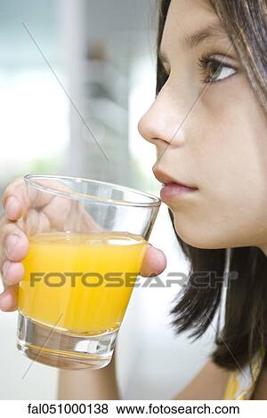 Girl drinking glass of orange juice View Large Photo Image Stock Photo - Girl drinking glass of orange juice. Fotosearch